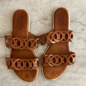 Brown leather slip on sandals.